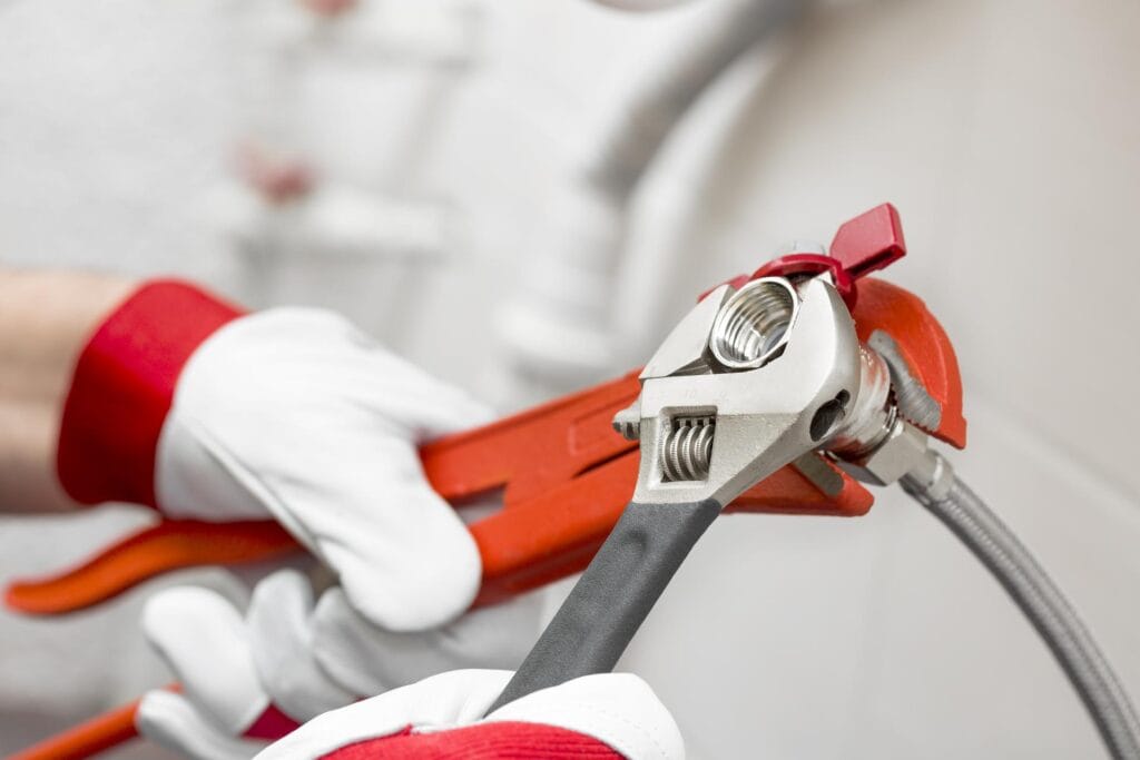 Plumber holding pipe wrenches for an emergency repair in Lake Worth Beach