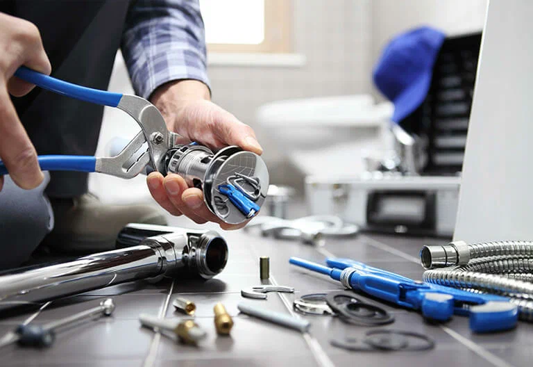 Technician repairing a plumbing fixture with professional tools in Lake Worth Beach