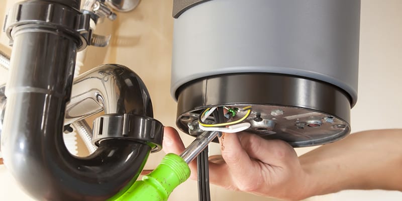 Technician repairing the heating element of a water heater in Lake Worth Beach