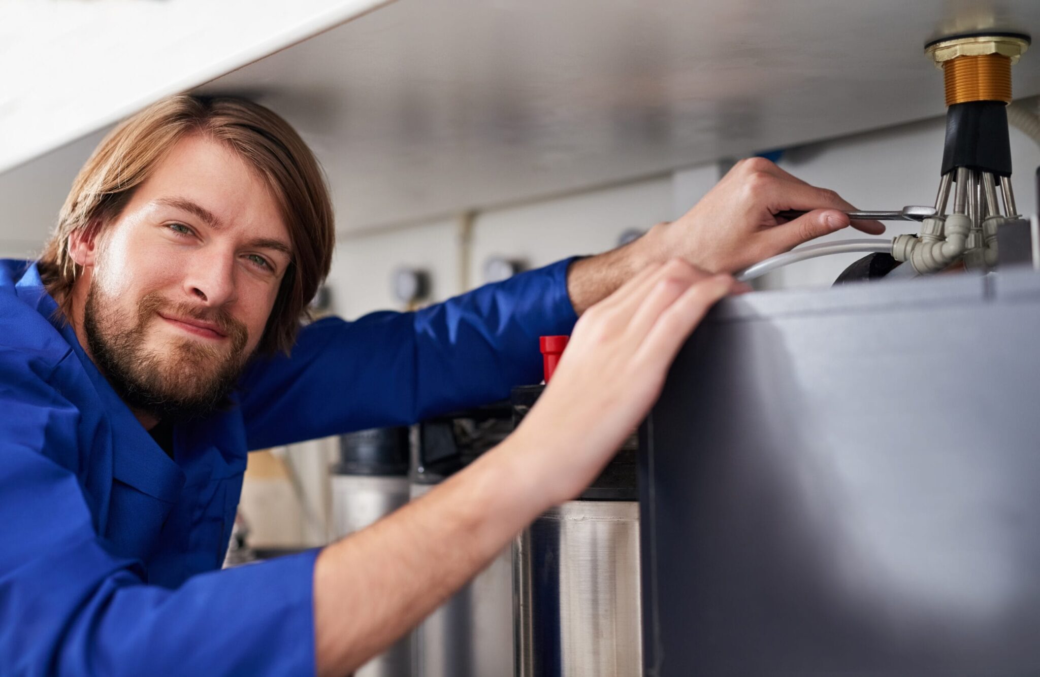 Technician servicing a residential water heater tank in Lake Worth Beach
