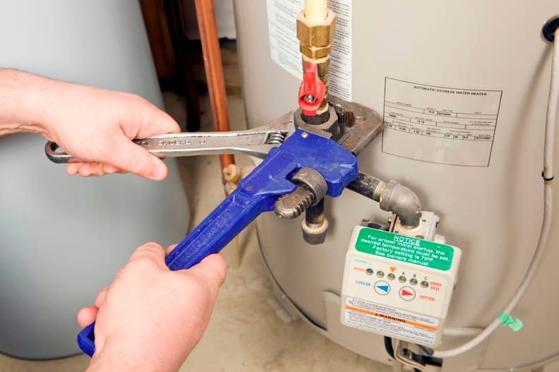 Plumber repairing a water heater valve in Lake Worth Beach